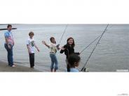 Five kids fishing in river, waving to camera