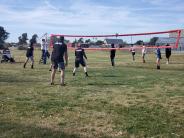 Police officers playing volleyball with high school students