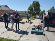 Two Rio Vista police officers returning stolen tools to the rightful owner and receiving a hug.