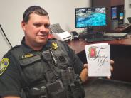 Police Officer holding a thank-you card