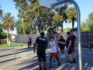 Police officers playing basketball with high school students and shaking hands