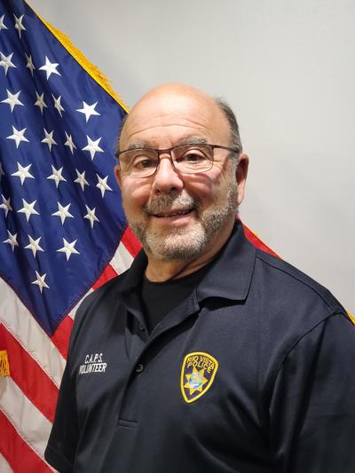 Male police chaplain in front of American flag